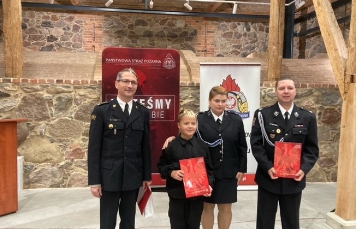 zdjęcie przedstawicieli drużyn strażackich z promesą