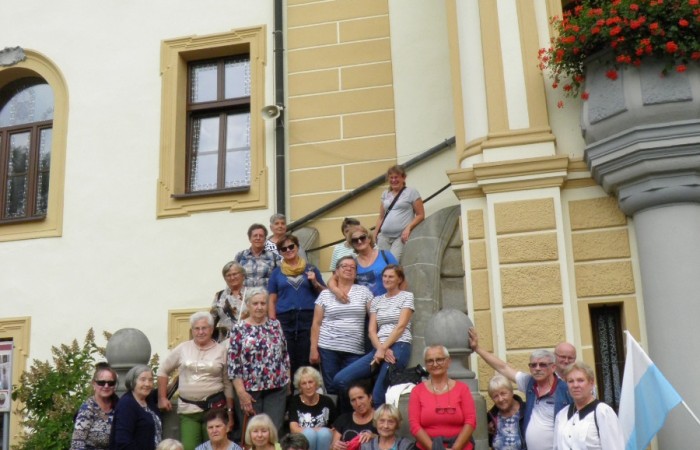 Wspólne zdjęcie uczestników wycieczki siedzącch na schodach