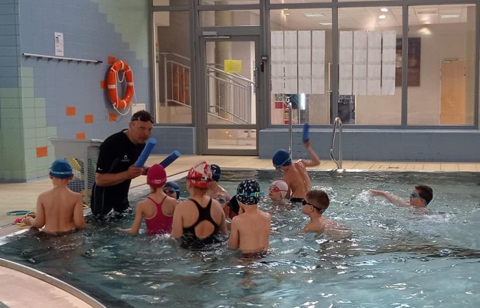 zdjęcie dzieci na basenie z instruktorem pływania