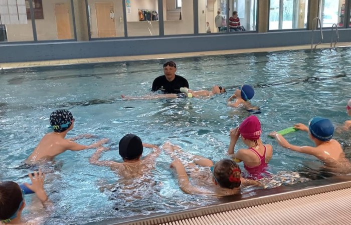 zdjęcie dzieci na basenie z instruktorem pływania